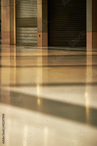 Empty marble floor with dark lines in front of shutters