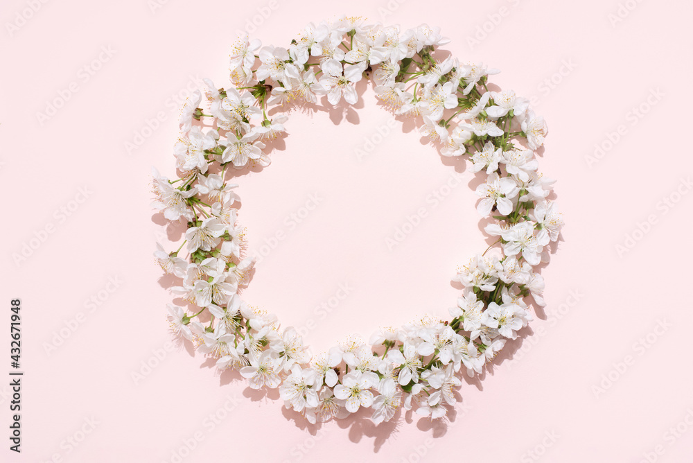 Round frame, wreath of white cherry flowers on a pink background, spring, wedding background.