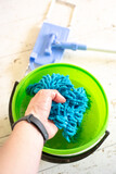Washing a doormat in a bucket of water. Room cleaning.