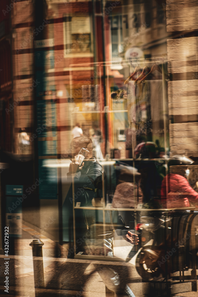 Obraz People walking through a restaurant window