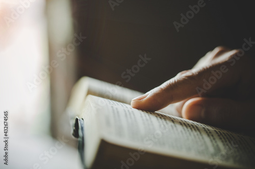 Photo woman's hands while reading the Bible.