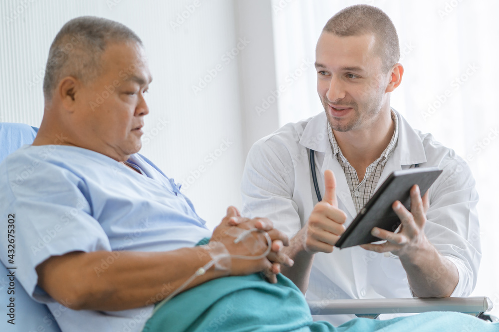 Fototapeta premium happy asian elderly looking at a good result of health check up in the medical chart with doctor.