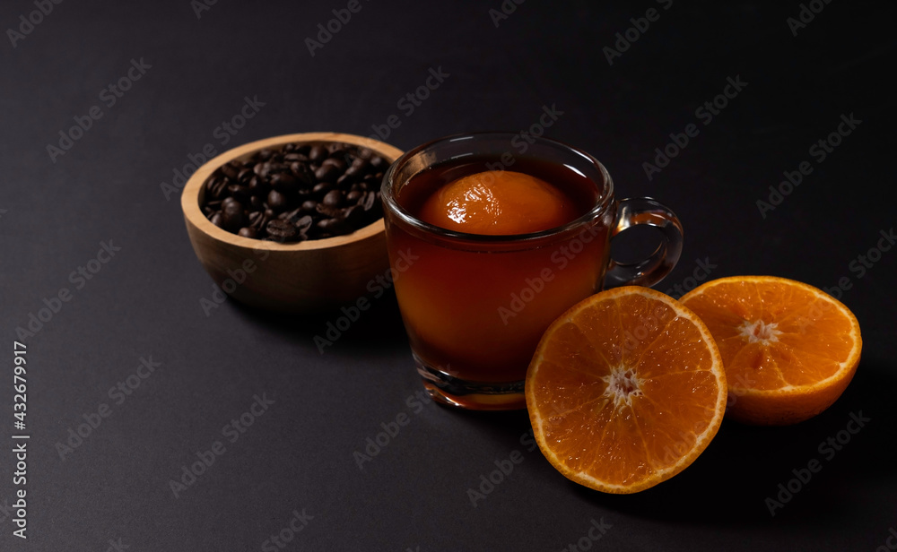 Cold brewed coffee with ice ball made from orange juice on black background. Cold brewed coffee with ice ball made from orange juice on black background.