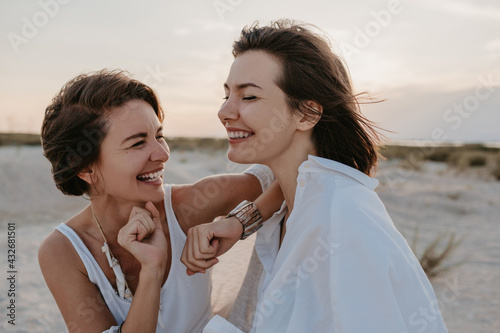 two young women having fun on the sunset beach