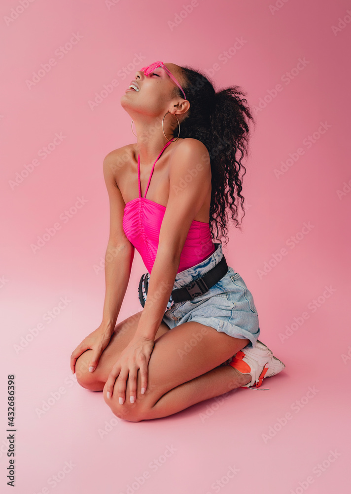 attractive black african american woman in stylish outfit on pink background attractive black african american woman in stylish outfit on pink background