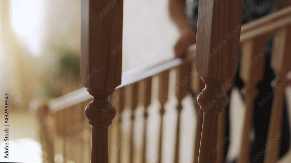Woman climbing the stairs in the house and holding on to the handrail Woman climbing the stairs in the house and holding on to the handrail