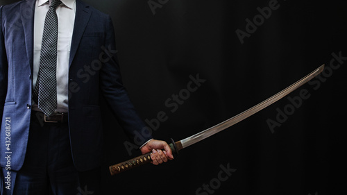 日本刀を構えるスーツの人物