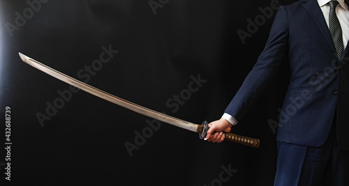 日本刀を構えるスーツの人物