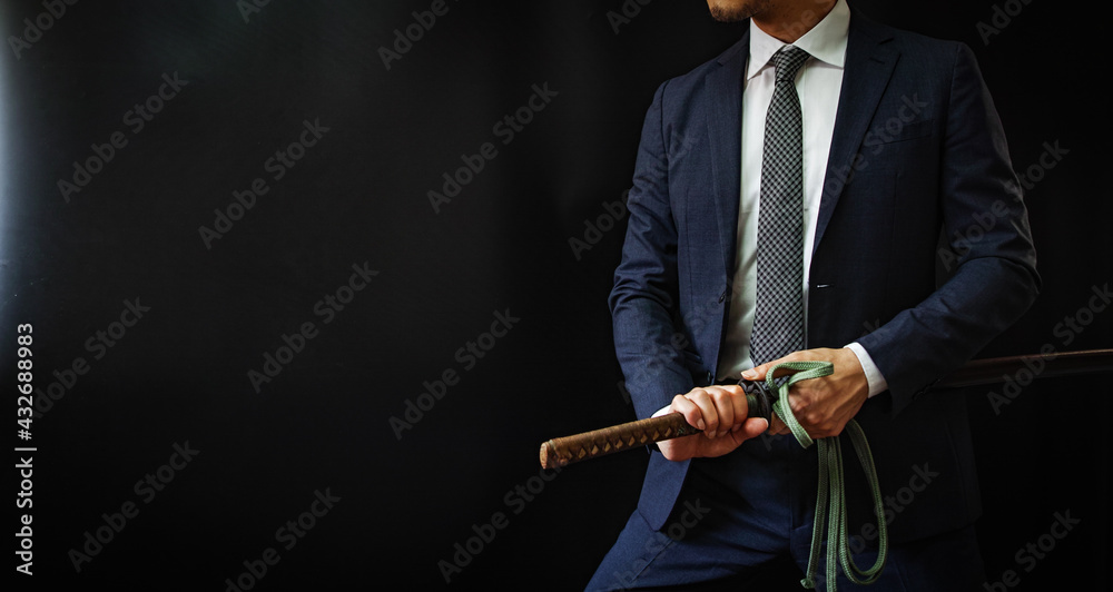 日本刀を構えるスーツの人物