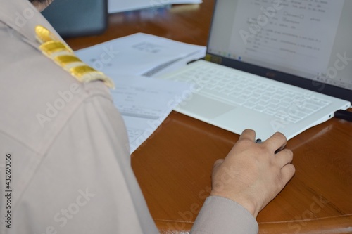 Thai teachers in Thai government uniforms are working on a computer