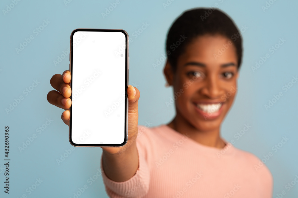 Mobile Offer. Smartphone With White Screen In Hands Of Cheerful Black Woman