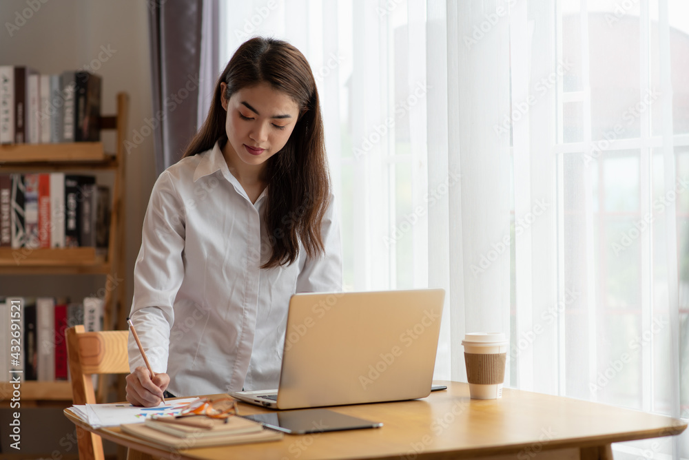 Young Asian businesswoman working at her house with laptop, working at home, business concept Young Asian businesswoman working at her house with laptop, working at home, business concept