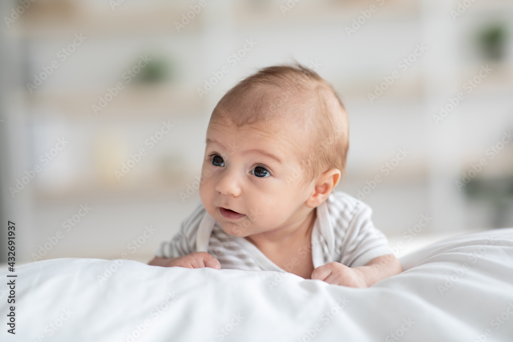 Closeup Shot Of Adorable Newborn Baby Crawling On Bed At Home Closeup Shot Of Adorable Newborn Baby Crawling On Bed At Home