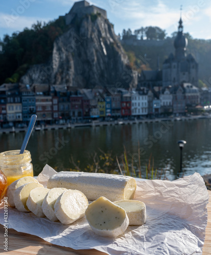 Belgian abbey cheese fagotin in pieces with jam served outdoor with view on Maas river and center of Dinant, Wallonia, Belgium photo