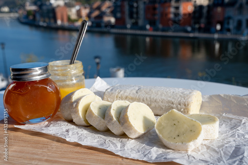 Belgian abbey cheese fagotin in pieces with jam served outdoor with view on Maas river and center of Dinant, Wallonia, Belgium photo