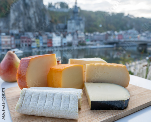 Cheese collection, Belgian abbey cheeses made with brown trappist beer and fine herbs and view on Maas river in Dinant, Wallonia, Belgium photo