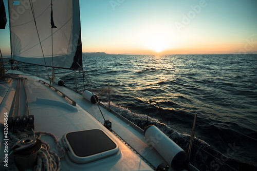 Sailing boat in the sea during amazing sunset. Luxury yacht and cruise holiday.