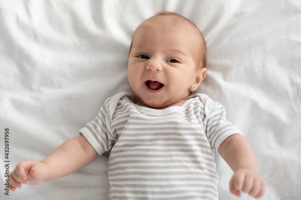Adorable Baby Portrait. Closeup Shot Of Cute Newborn Child Relaxing On Bed Adorable Baby Portrait. Closeup Shot Of Cute Newborn Child Relaxing On Bed