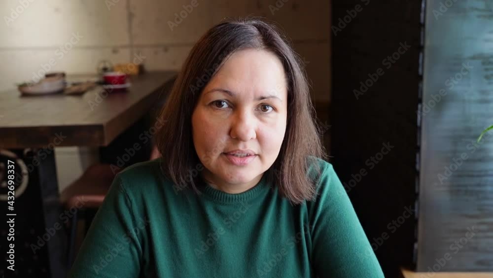 Pretty woman sitting in cafe and talking. Green dress with long sleeves. Casual lifestyle portrait. Business female person interview professional. Vlog slow video Pretty woman sitting in cafe and talking. Green dress with long sleeves. Casual lifestyle portrait. Business female person interview professional. Vlog slow video