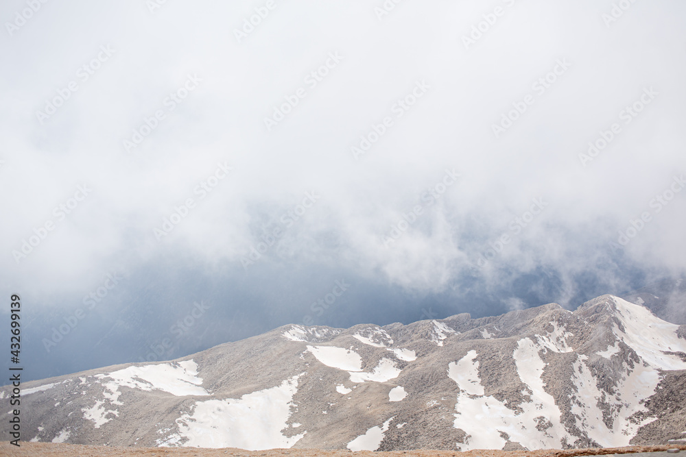 Snowy mountain peaks surrounded with clouds Snowy mountain peaks surrounded with clouds
