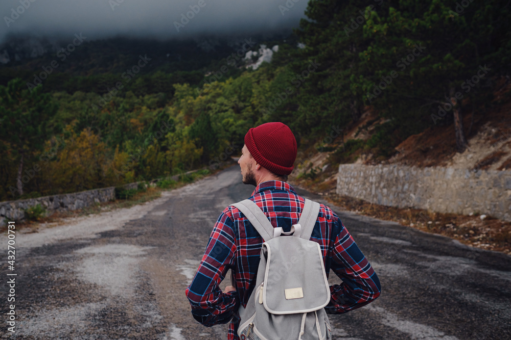 Man traveling with a backpack hiking in the mountains travel.