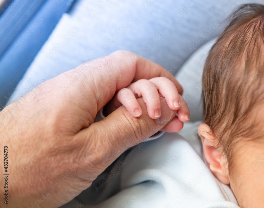 Peaceful and sleepy newborn baby, focus on the hand; family and love theme photography Peaceful and sleepy newborn baby, focus on the hand; family and love theme photography