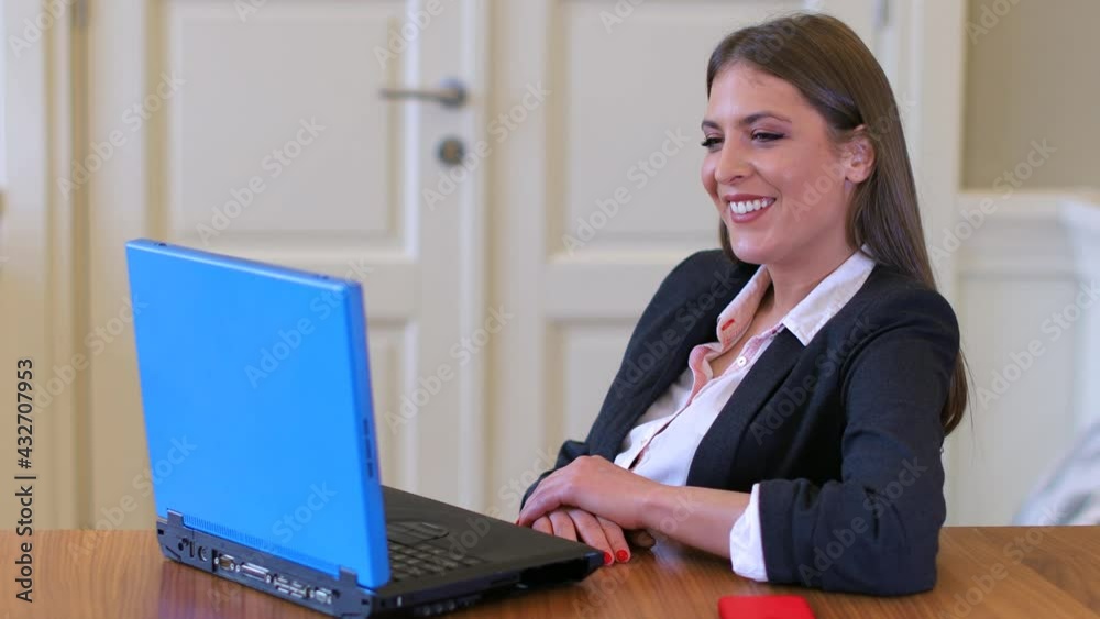 young woman sitting and smiling while looking at notepad young woman sitting and smiling while looking at notepad