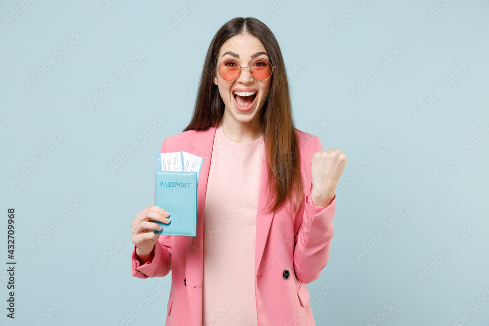 Traveler tourist woman in pastel pink clothes glasses hold passport tickets do winner gesture clench fist isolated on blue background Passenger travel abroad weekend getaway Airflight journey concept Traveler tourist woman in pastel pink clothes glasses hold passport tickets do winner gesture clench fist isolated on blue background Passenger travel abroad weekend getaway Airflight journey concept