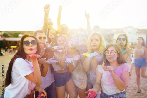 A group of friends have fun, dance at the holi festival. Spring Break Beach Party. Celebrating traditional indian spring holiday. Friendship, Leisure, Vacation, Togetherness.