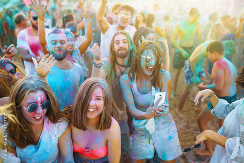 A group of friends have fun, dance at the holi festival. Spring Break Beach Party. Celebrating traditional indian spring holiday. Friendship, Leisure, Vacation, Togetherness.
