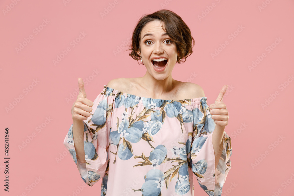 Young smiling happy stylish satisfied caucasian woman 20s with short hairdo wear trendy blouse show thumbs up like gesture isolated on pastel pink background studio portrait. People lifestyle concept. Young smiling happy stylish satisfied caucasian woman 20s with short hairdo wear trendy blouse show thumbs up like gesture isolated on pastel pink background studio portrait. People lifestyle concept.