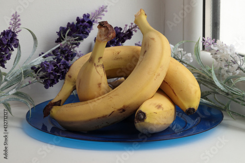Still life with bananas and artificial flowers.