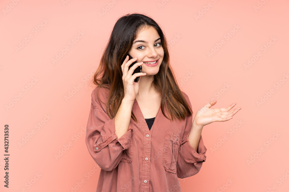 Young caucasian woman isolated on pink background keeping a conversation with the mobile phone with someone Young caucasian woman isolated on pink background keeping a conversation with the mobile phone with someone