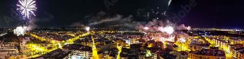 Panoramica sobre pueblo valenciano lanzando cohetes en fiestas de Fallas. Fotografia tomada con drone