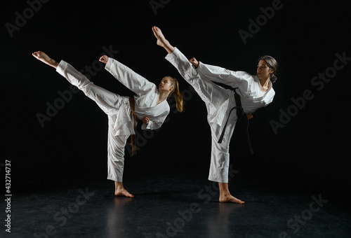 Female karatekas in kimono, combat stance