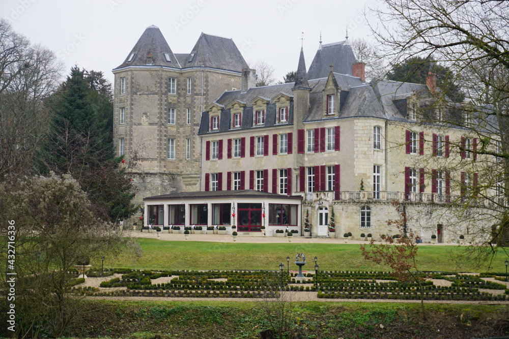 old limestone castle in the park with red wood shutters and gardens in the Loire valley, France