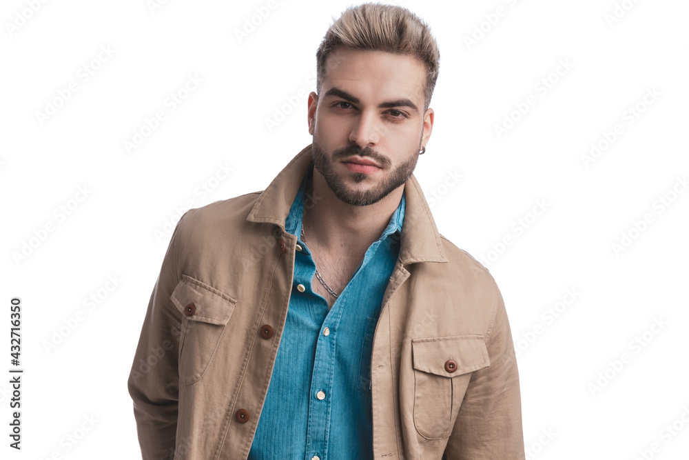 happy unshaved man in beige jacket and denim shirt smiling and posing happy unshaved man in beige jacket and denim shirt smiling and posing