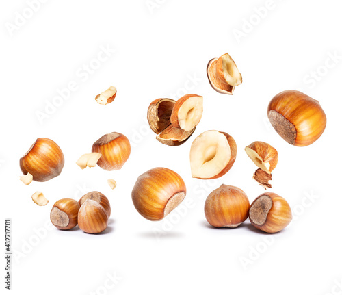 Group of hazelnuts are falling down close-up on a white background