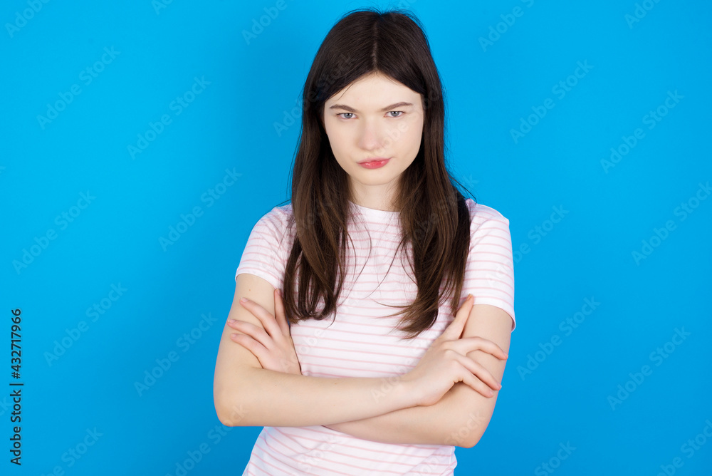 young beautiful Caucasian woman wearing stripped T-shirt over blue wall Pointing down with fingers showing advertisement, surprised face and open mouth young beautiful Caucasian woman wearing stripped T-shirt over blue wall Pointing down with fingers showing advertisement, surprised face and open mouth