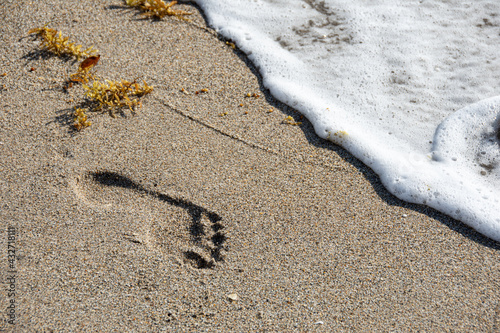 Surf washing away footprints in sand