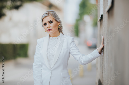 Blonde female posing in an elegant white pantsuit