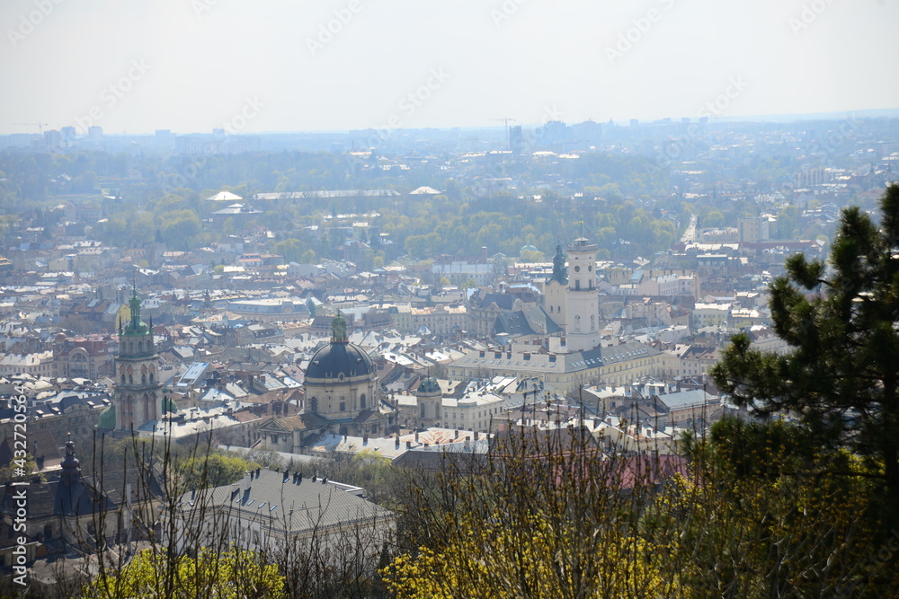 LVIV, UKRAINE - APRIL 17, 2019: People tourists at the top of High Castle Hill, Ukrainian city old town mountain peak on sunny summer day cityscape. Lviv city seen from mount on High Castle Hill