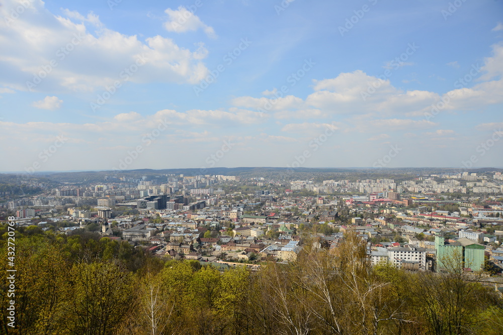 LVIV, UKRAINE - APRIL 17, 2019: People tourists at the top of High Castle Hill, Ukrainian city old town mountain peak on sunny summer day cityscape. Lviv city seen from mount on High Castle Hill