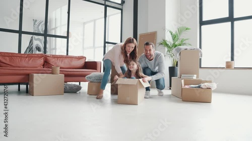 Playful young family having fun together while moving into a new apartment 