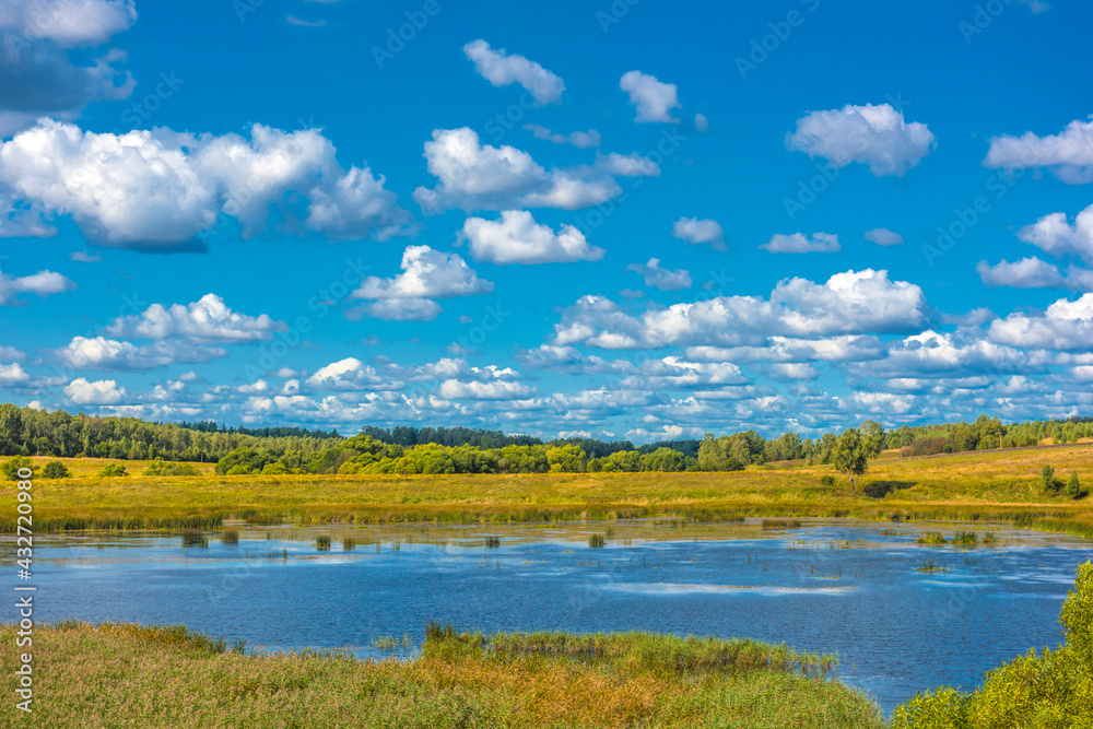 Clouds over the lake and field in autumn Clouds over the lake and field in autumn