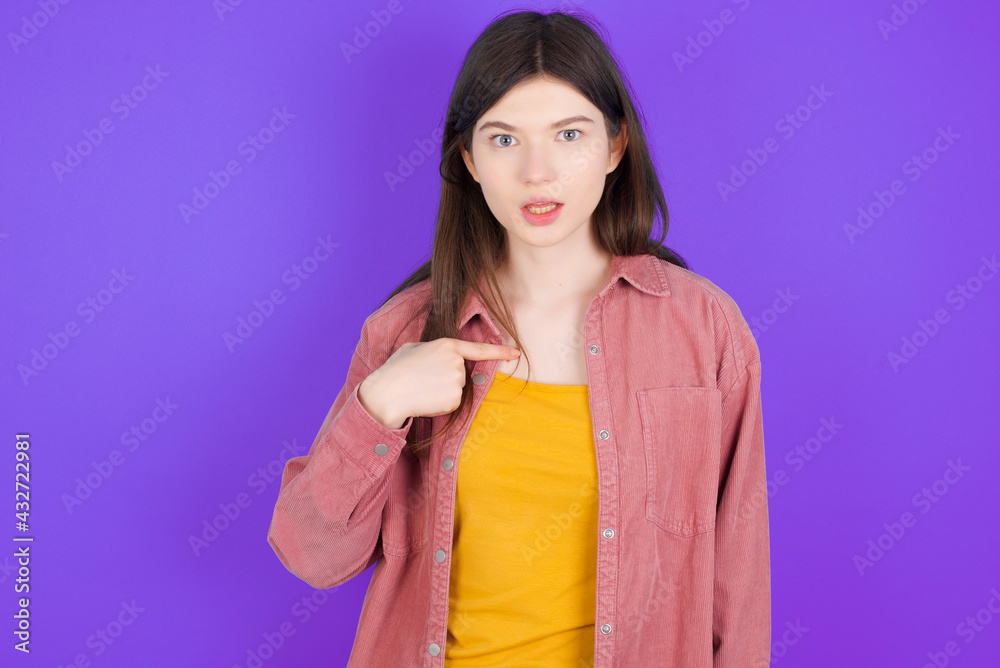 young beautiful Caucasian woman wearing casual clothes over purple wall being in stupor shocked, has astonished expression pointing at oneself with finger saying: Who me? young beautiful Caucasian woman wearing casual clothes over purple wall being in stupor shocked, has astonished expression pointing at oneself with finger saying: Who me?