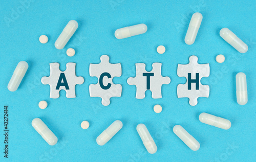 On a blue background, there are pills and puzzles with the inscription - ACTH