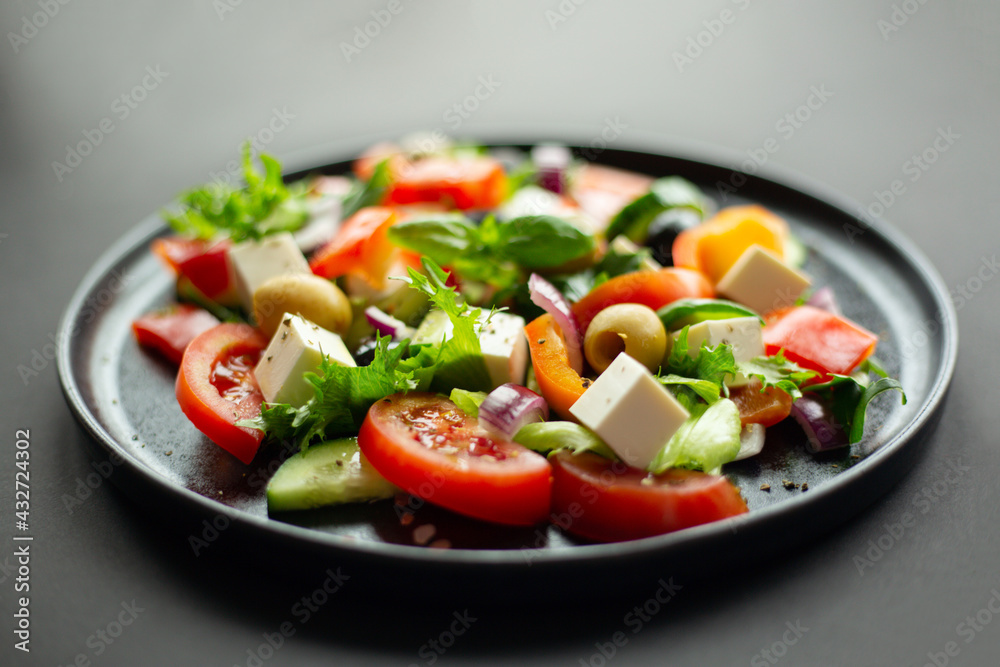 Greek salad on black plate