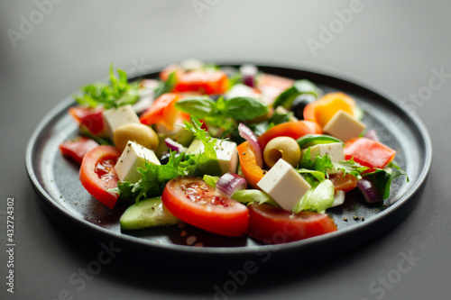 Greek salad on black plate
