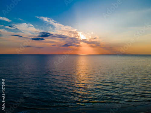 Fototapeta Naklejka Na Ścianę i Meble -  Beautiful colorful sunset among clouds over a slightly undulating sea